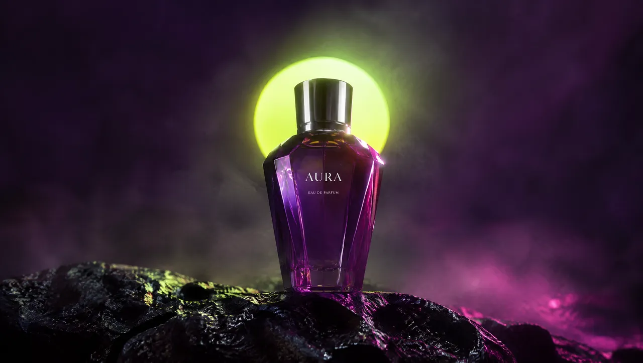 A violet perfume bottle on black rock, glowing orb behind